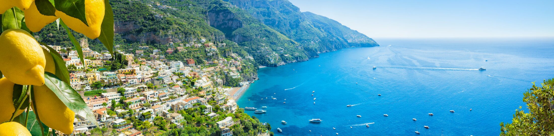 Panoramablick auf Positano mit bequemen Stränden und blauem Meer an der Amalfiküste in Kampanien, Italien. Die Amalfiküste ist ein beliebtes Reise- und Urlaubsziel in Europa. Reife gelbe Zitronen im Vordergrund. | © ©IgorZh - stock.adobe.com