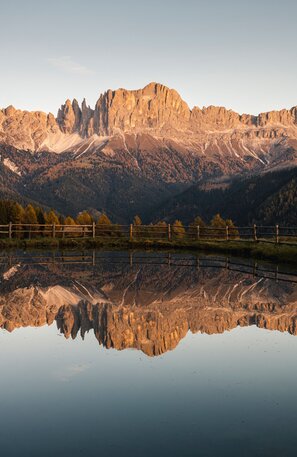 © Die tiefer stehende Sonne zeichnet die schroffen Berggipfel in einem warmen Licht. Foto: djd/IDM Südtirol/Alex Moling